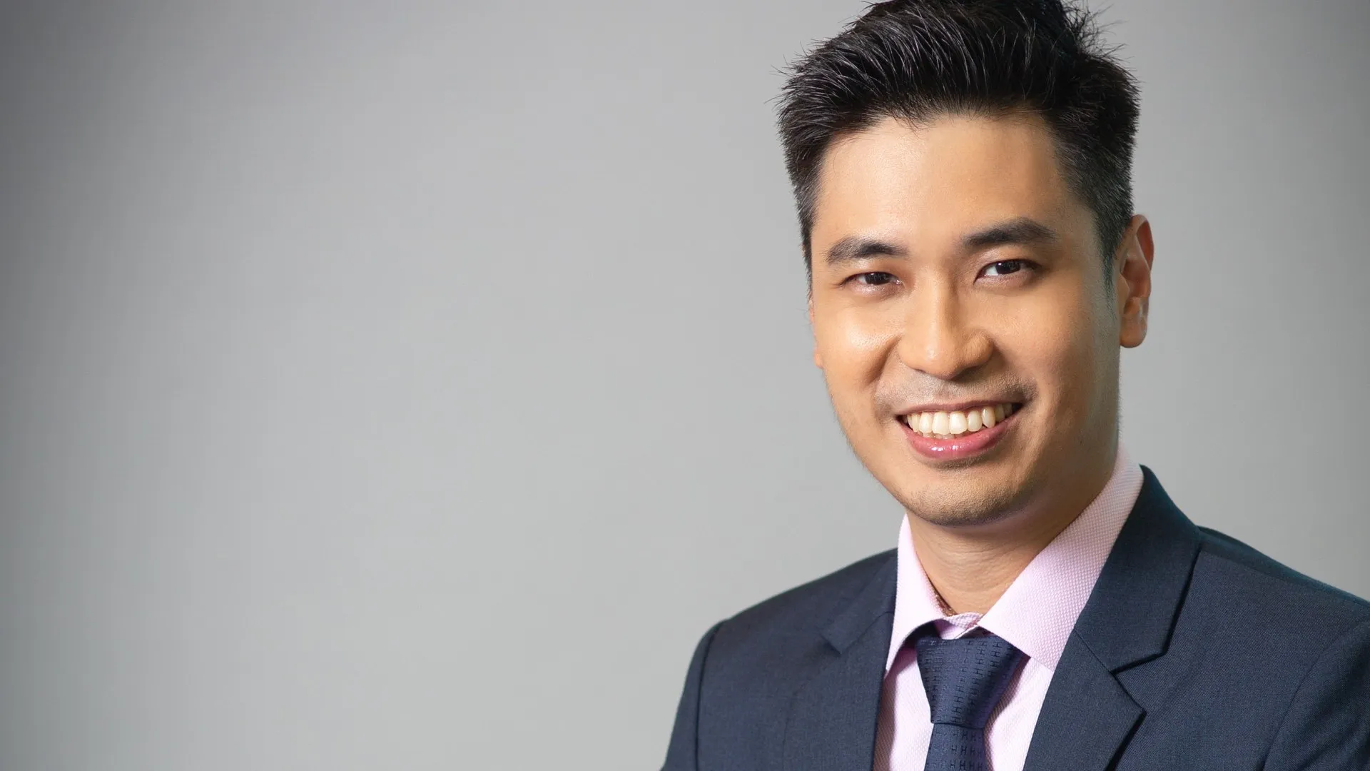 Ling Chun Wei, smiling, in a navy suit